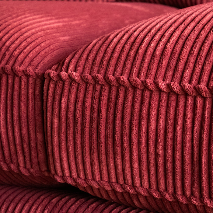 Close-up of a red corduroy velvet sofa cushion and welt 