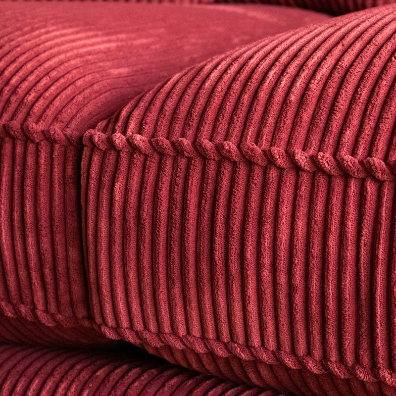 Close-up of a red corduroy velvet sofa cushion and welt 