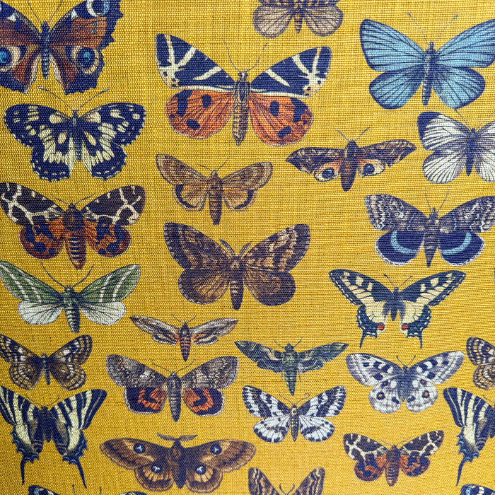 Close-up of yellow-gold fabric with allover butterfly pattern