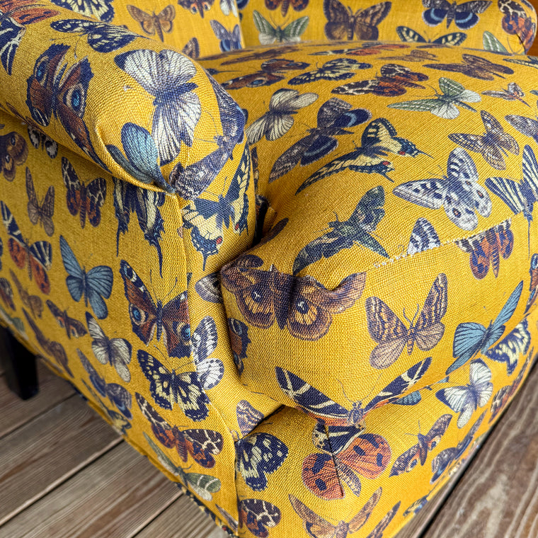 Close-up of yellow-gold fabric with allover butterfly pattern
