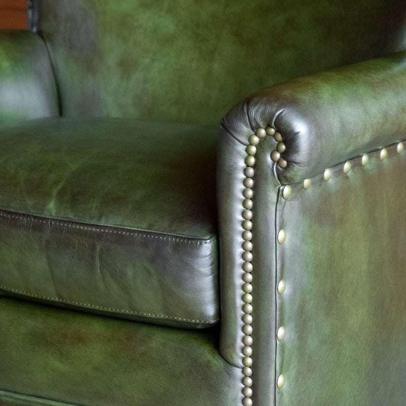 Close-up of the arm of a green leather swivel chair