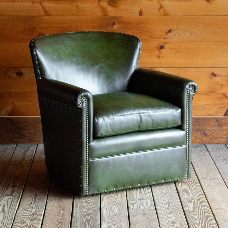 Angled front view of a green leather swivel chair against a wooden wall