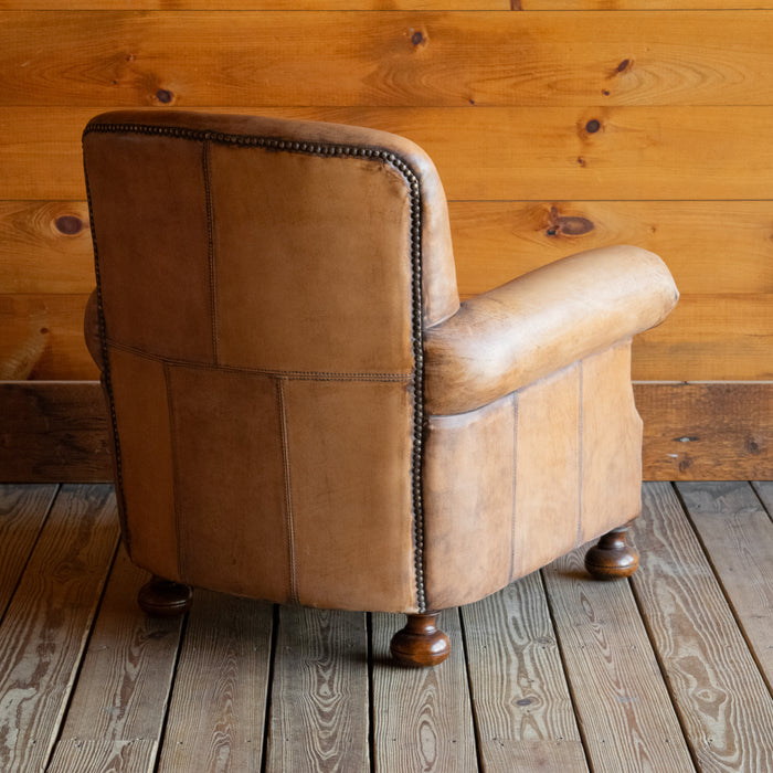 Angled back view of buffalo leather rolled arm chair with decorative nailhead details