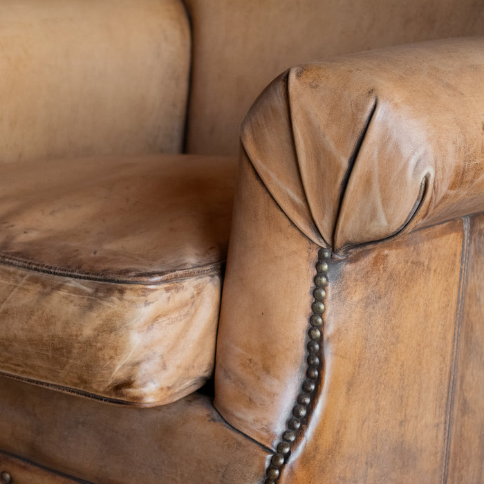 Arm close-up of buffalo leather rolled arm chair with decorative nailhead details