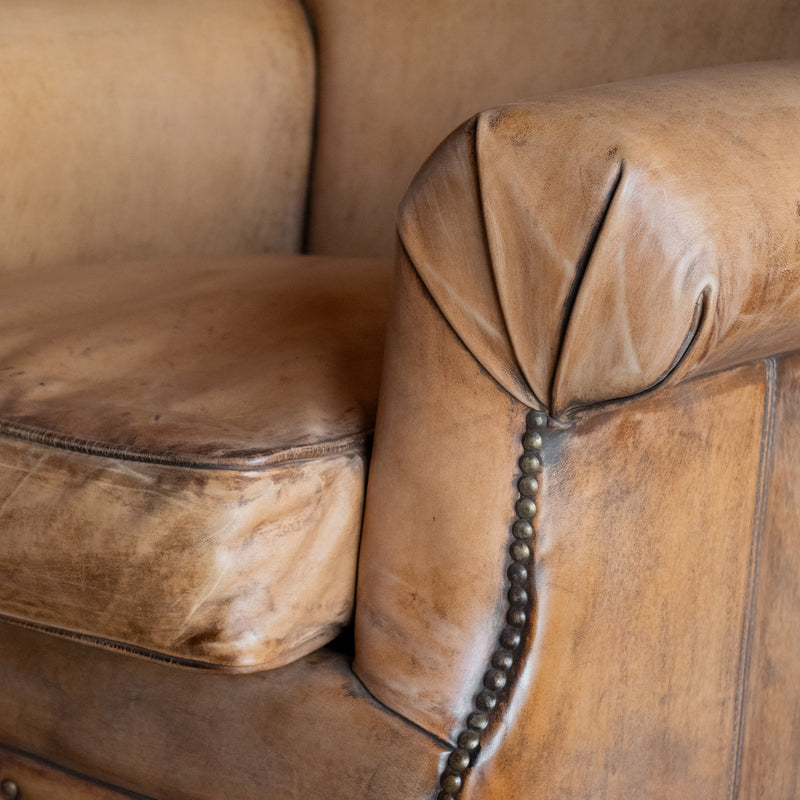 Arm close-up of buffalo leather rolled arm chair with decorative nailhead details