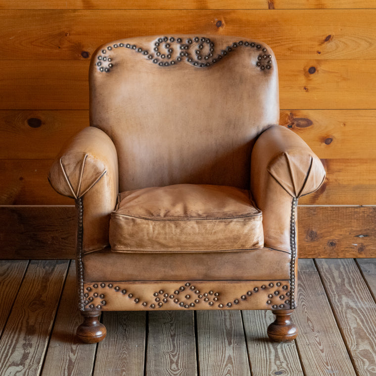 Angled back view of buffalo leather rolled arm chair with decorative nailhead details