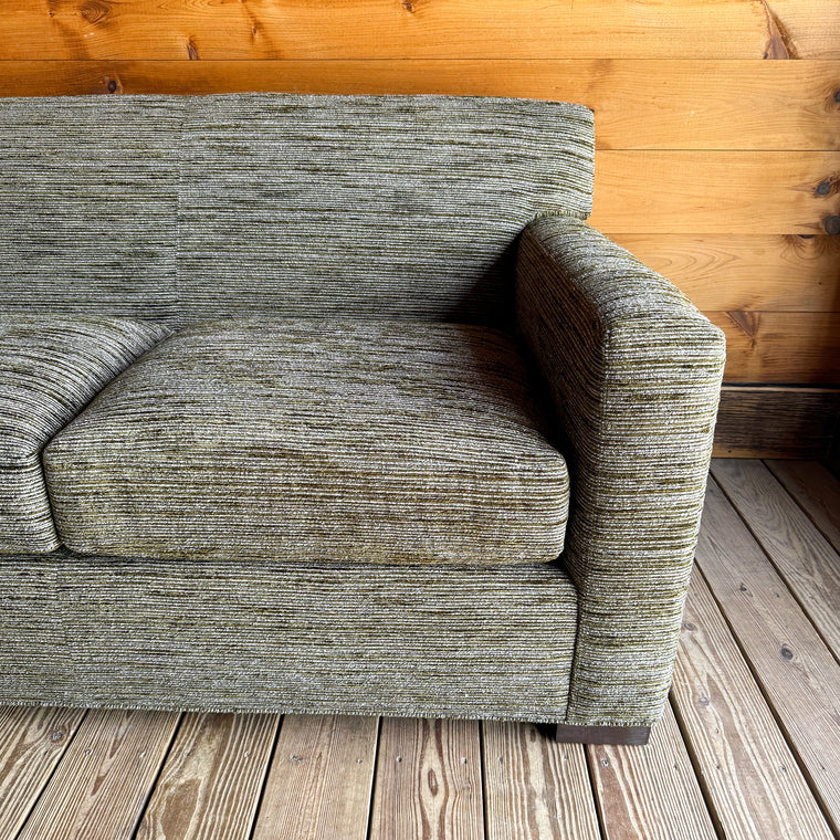 Close-up of a mottled moss green upholstery fabric