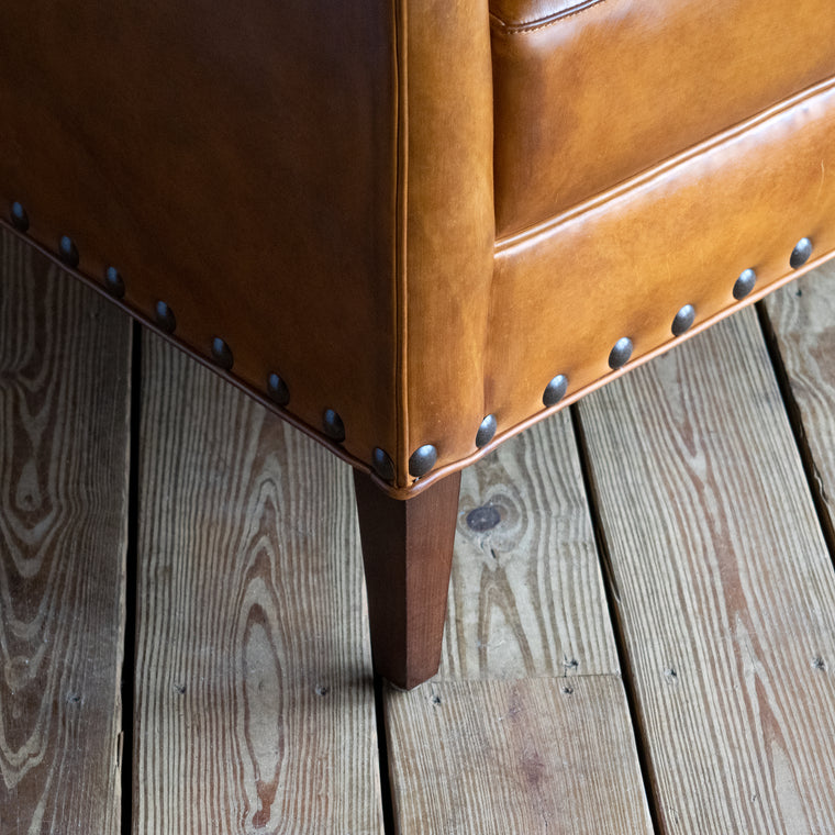 Curved Arm Chair Upholstered in Burnished Walnut Leather with Nailhead Trim